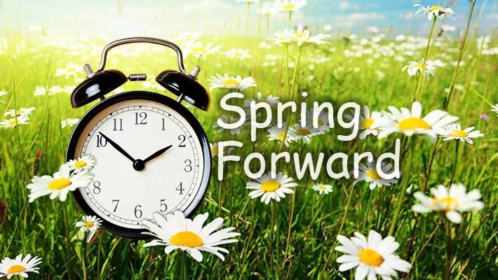 A field of white flowers with a clock and the words Spring Forward.