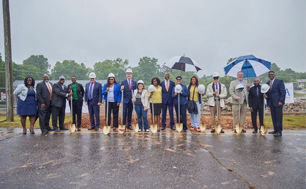 Various individuals standing outside in the rain with umbrellas.