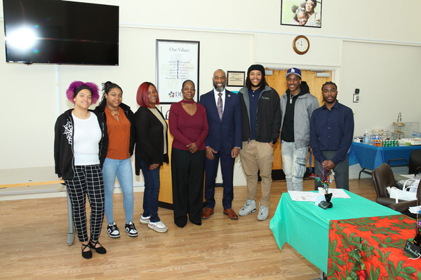 A group of individuals standing side by side while smiling.