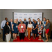 A big group of individuals posing with an award in front of a North Carolina Housing backdrop.