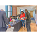 Individuals reading flyers while standing around a check-in table.