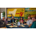 Six individuals with handouts sitting and smiling around a table.